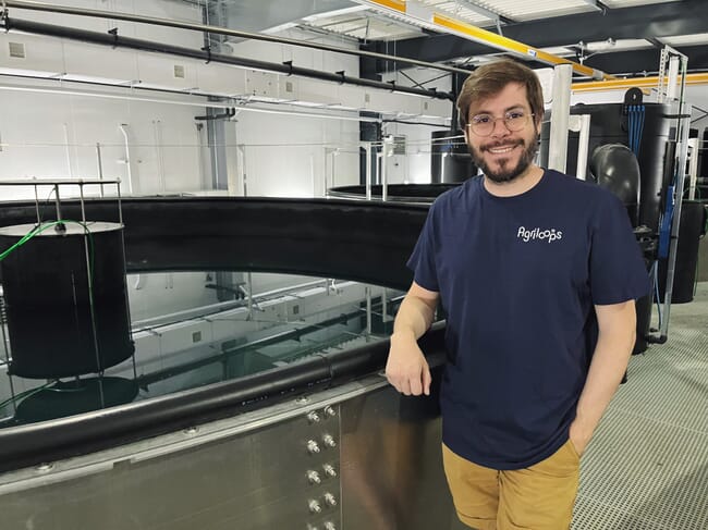 A man standing infront of a shrimp tank.