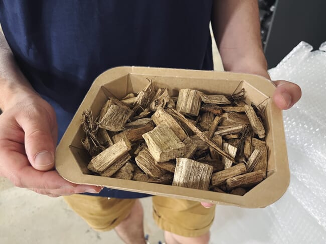 A person holding woodchips.