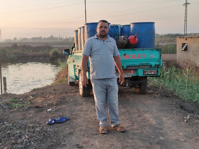 A man standing beside a pickup truck.