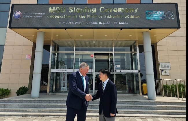 Two men in suits shaking hands.