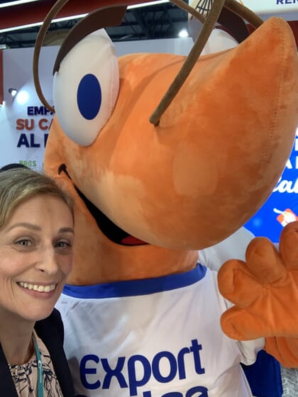 A woman beside a person in a shrimp suit.