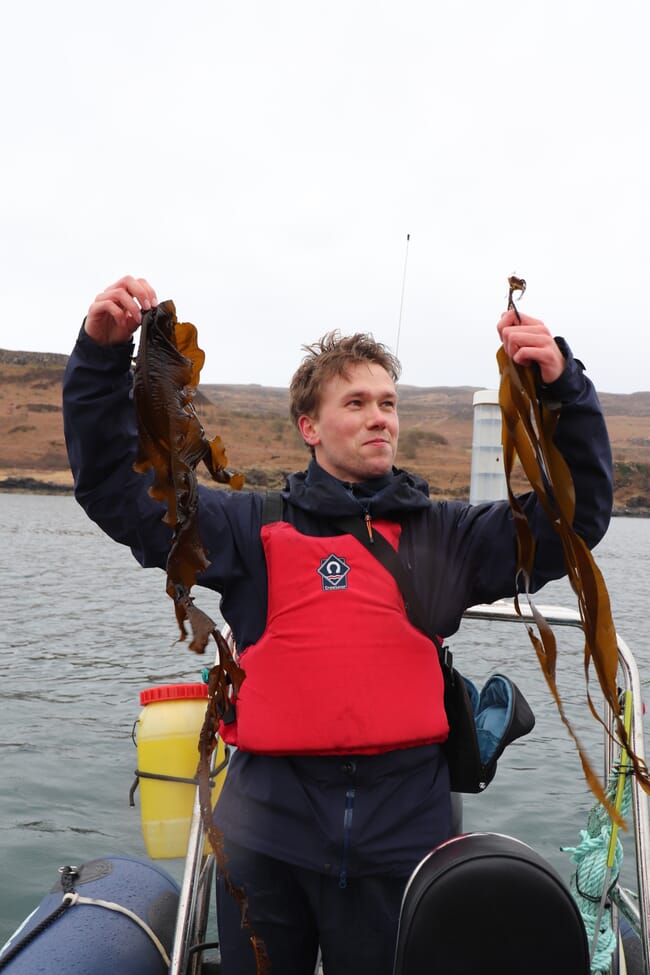 A seaweed farmer holding seaweed.