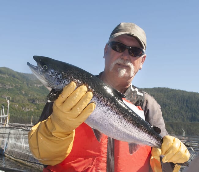 A man holding a salmon.