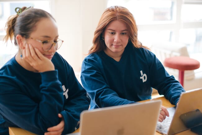 Two women working on a laptop.