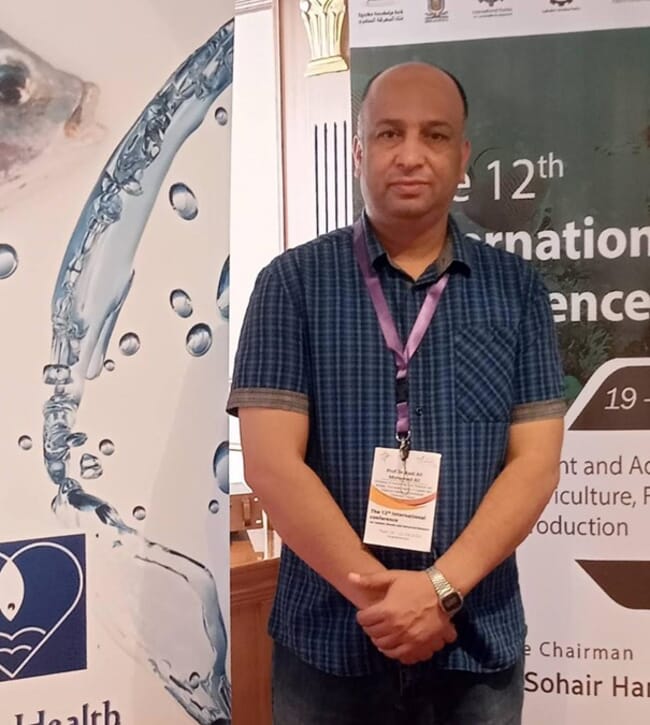 A man standing in front of a poster for a conference.