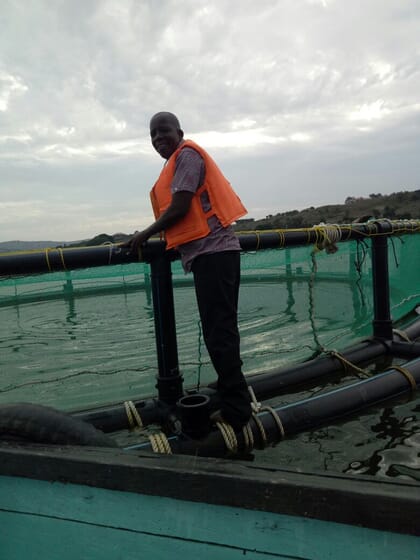 Enos Were standing on a fish cage