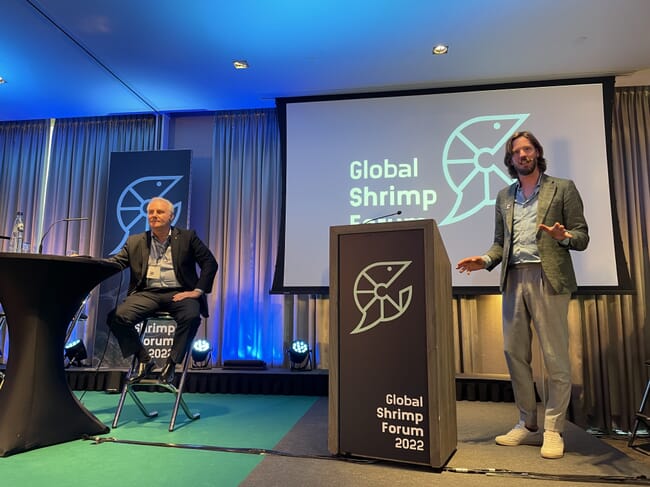 Two men on a conference stage.