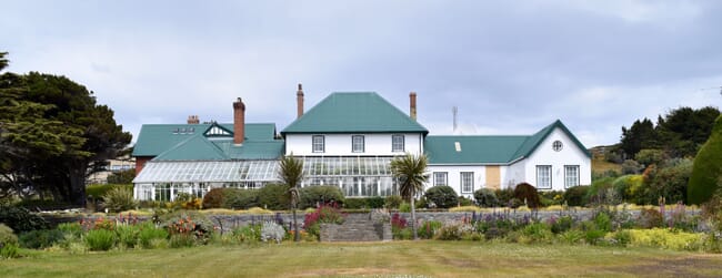 A white house with a green roof.