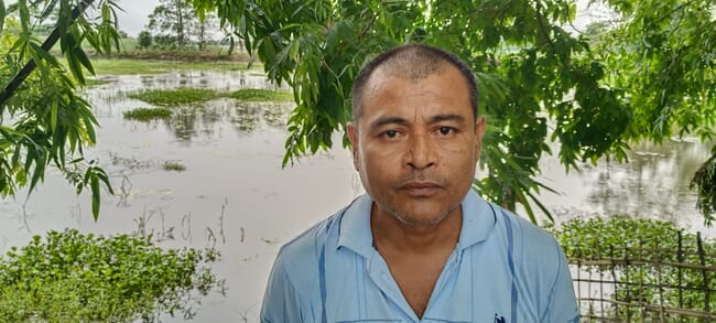 A man standing in front of a pond