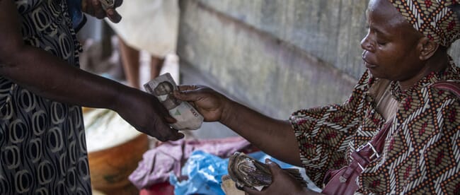 A person giving money to another person.