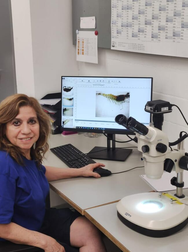 Janeth Chavez Zambrano sitting near a microscope