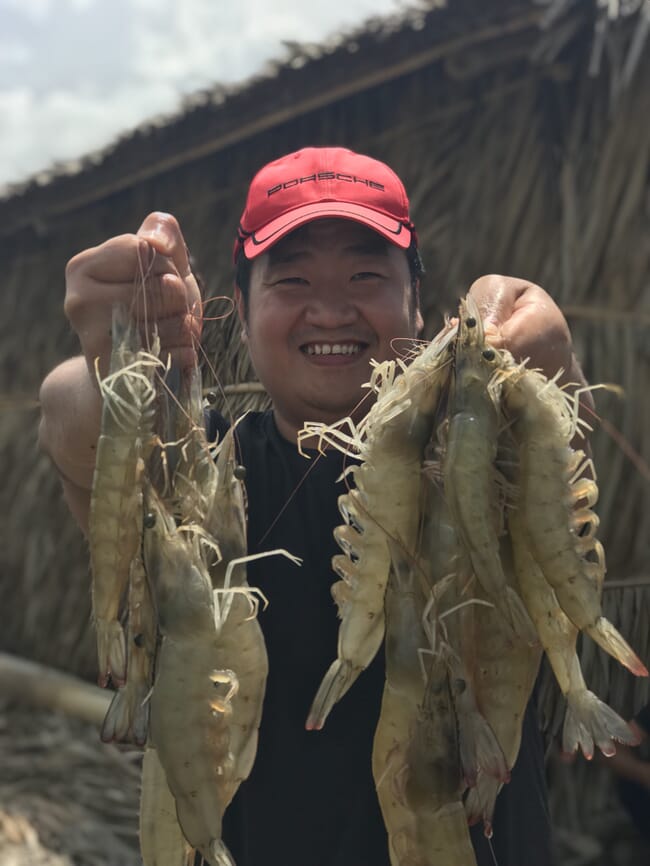 Loc Tran holding shrimp.