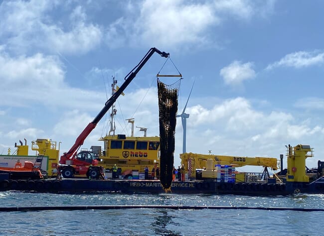 A boat collecting seaweed from a farm.