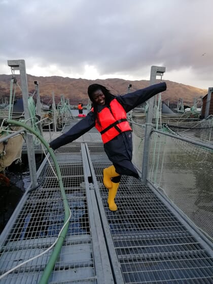 Woman posing near sea cages