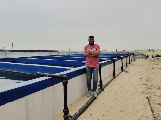 Man standing next to a farm.