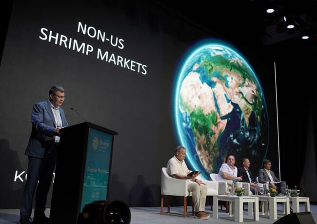 A man giving a presentation at a shrimp conference in Bali.