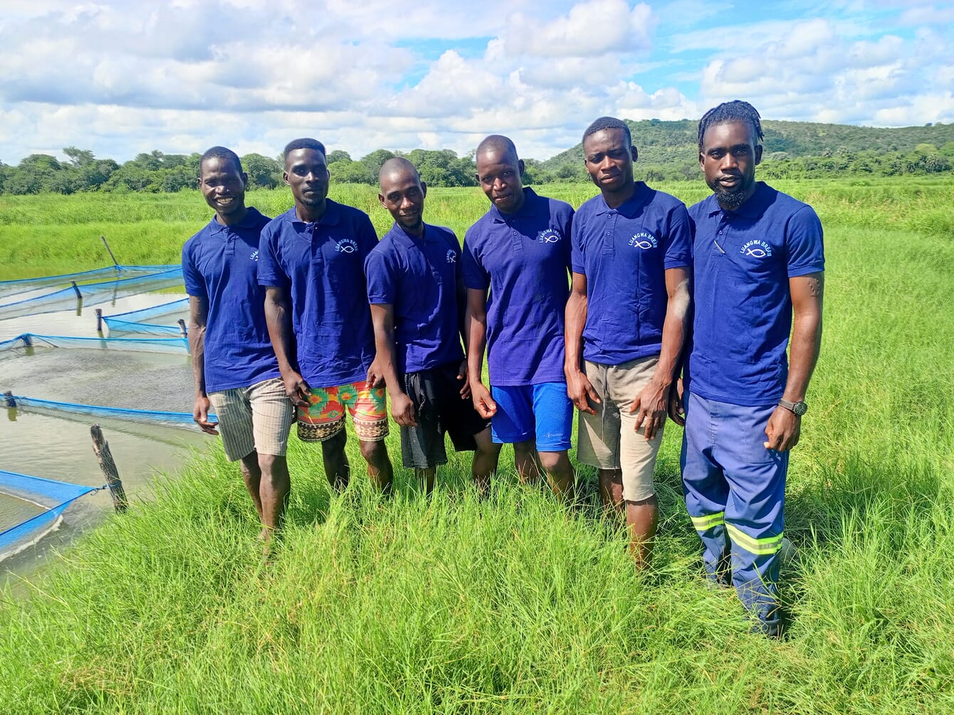 A group photo, beside a pond.