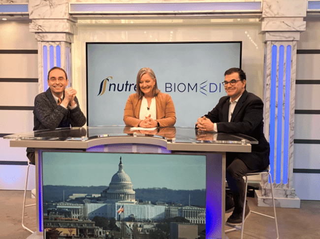 two men being interviewed at a newsdesk